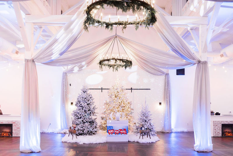 Three white and gold Christmas trees underneath a silky draping installation at 14TENN in Nashville, Tenneessee