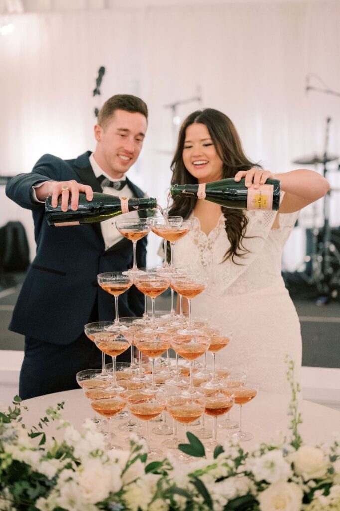 Kendall and Cole pour champagne onto a tower of glasses at their 14TENN wedding in Nashville
