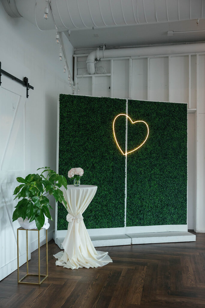 Greenery wall with neon heart sign at 14TENN
