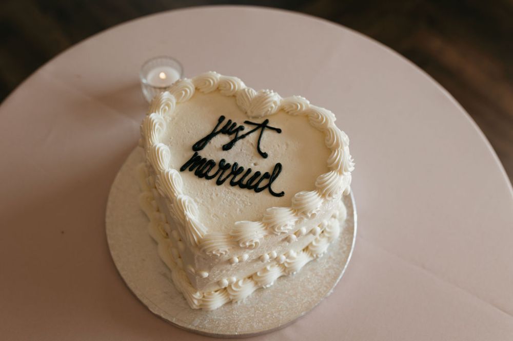 Heart-shaped wedding cake reading "just married"