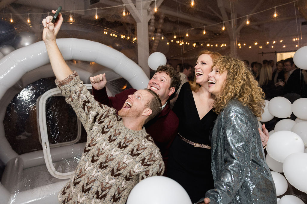 Guests taking a selfie at a holiday party at 14TENN