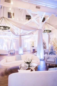 Holiday party at 14TENN with white draping, couches, and bright glowing lights.