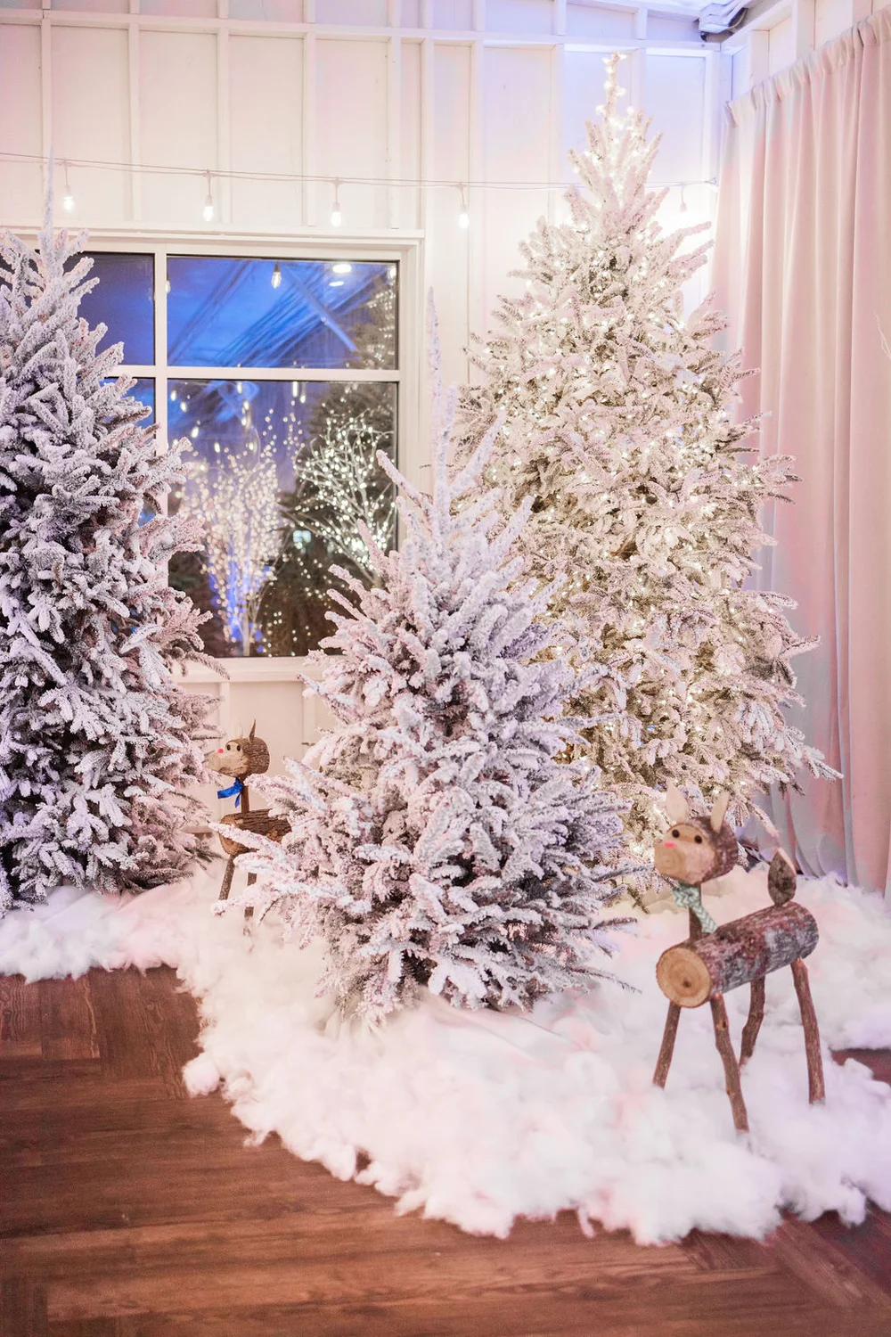 Christmas trees and a white fluffy rug set up at 14TENN for a company holiday party.