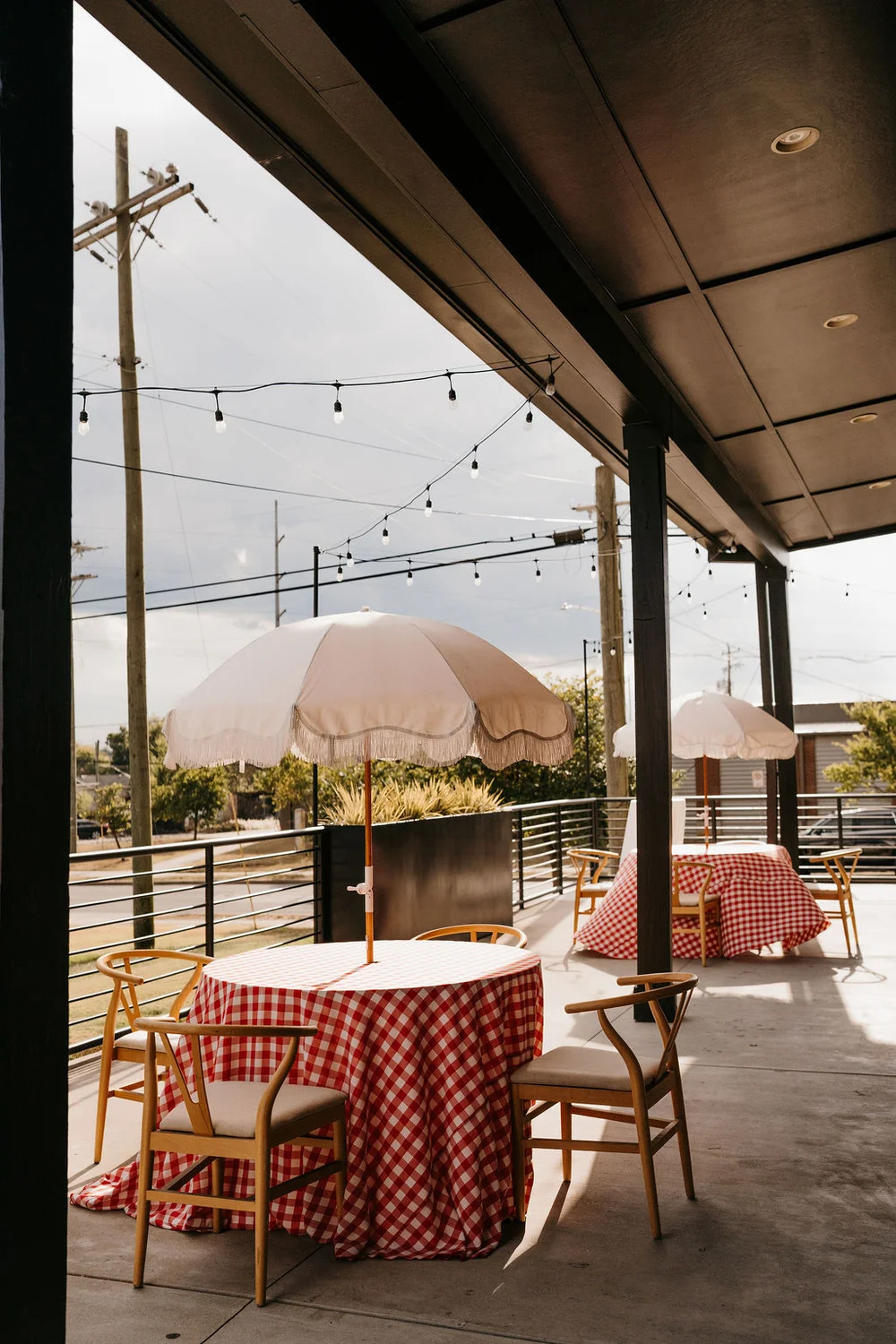 Tables set up outside on 14TENN's patio with gingham tablecloths and umbrellas