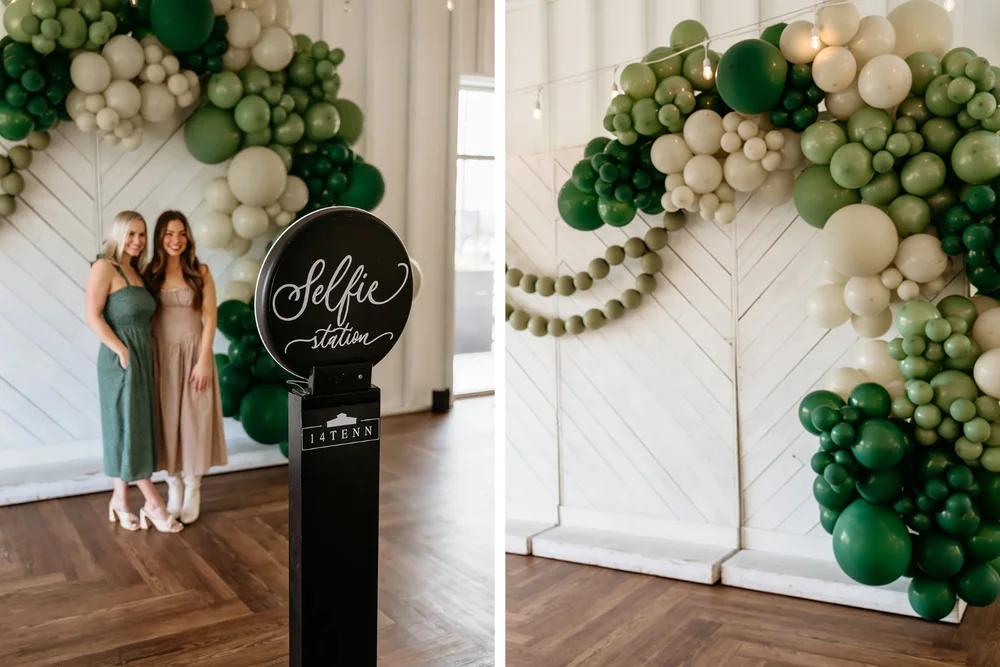 White wood backdrop with green balloons and selfie station at 14TENN wedding open house Nashville